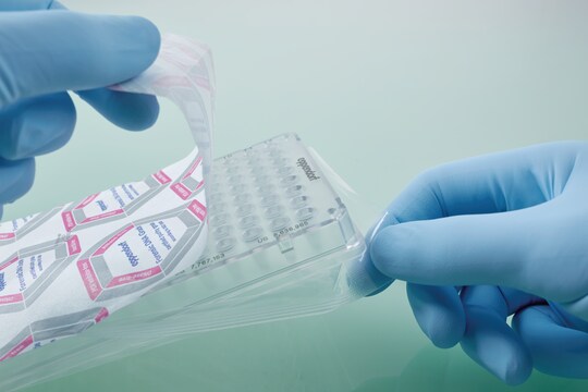 A scientist opening an individually wrapped forensic DNA grade PCR plate