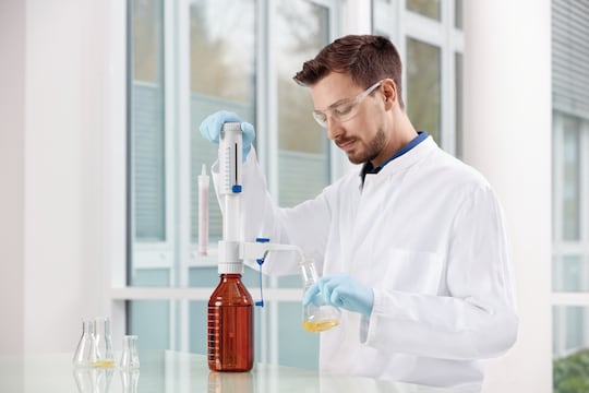 Lab technician using the Eppendorf Varispenser_REG_ 2x bottle-top dispenser to fill a glass vial