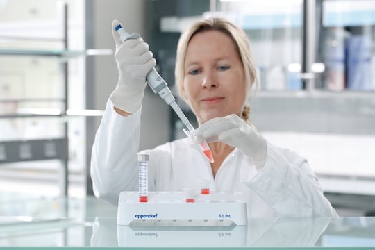 Scientist pipetting into Eppendorf 5 mL microtubes® stored in rack