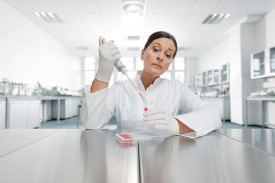 Lab worker pipetting from microtube to microplate