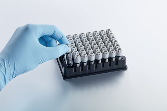 Scientist removes vial from Eppendorf CryoStorage Vial rack for downstream application