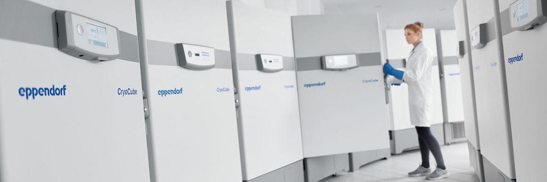 Eppendorf ULT Freezer Family with female lab scientist opening freezer door in the background