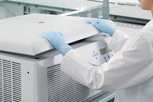 PhysioCare Concept® - Centrifuges A lab worker is closing the centrifuge lid in the laboratory.