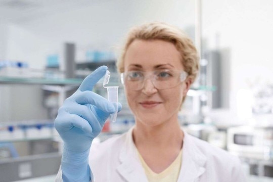 PhysioCare Concept® - Tubes A female scientist in the laboratory checks a conical tube that she has in her hand.
