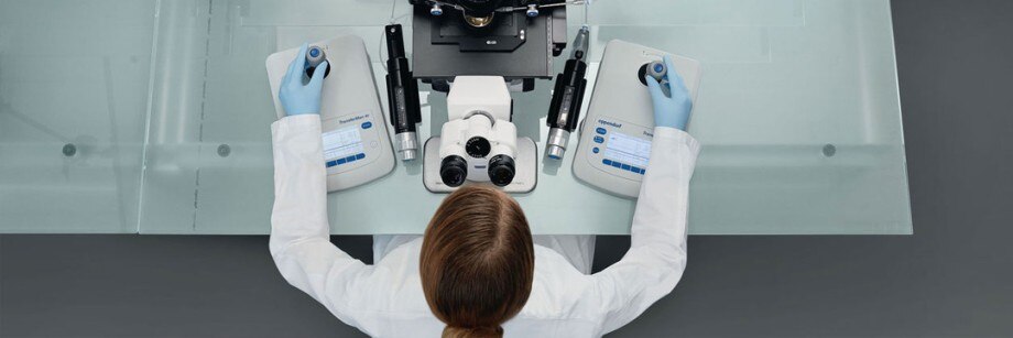 Ergonomic cell manipulation Scientist working in front of a microscope meanwhile she is using two ergonomic joysticks of Eppendorf for cell manipulation.