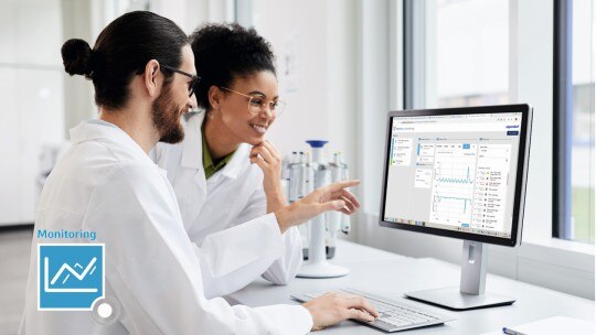 Remotely monitor your lab instruments with VisioNize, the laboratory monitoring system. A couple of scientists checking the monitoring dashboard of VisioNize on the computer.