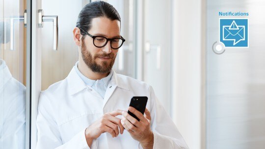 Receive notifications via email or SMS from your laboratory monitoring system VisioNize. Man using the laboratory monitoring system VisioNize® from his phone.