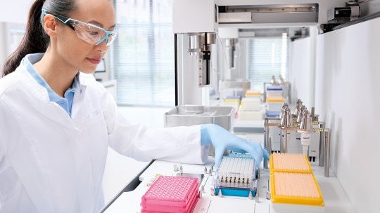 Precision-designed Eppendorf OEM plate for versatile laboratory applications Women at a bench working with plates.