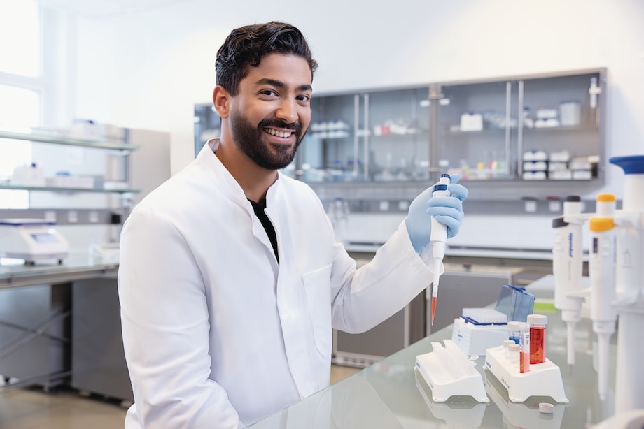 Happy scientist presents an Eppendorf Research® 3 neo single-channel pipette 50-1000 µL blue Happy scientist looks into camera and presents an Eppendorf Research® 3 neo single-channel pipette 50-1000 µL blue
