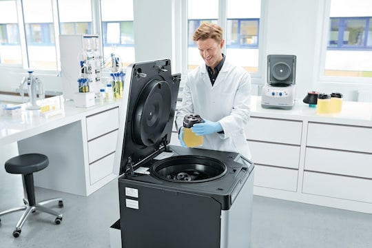 Man loading 1.5 L bottle into Centrifuge CR22N