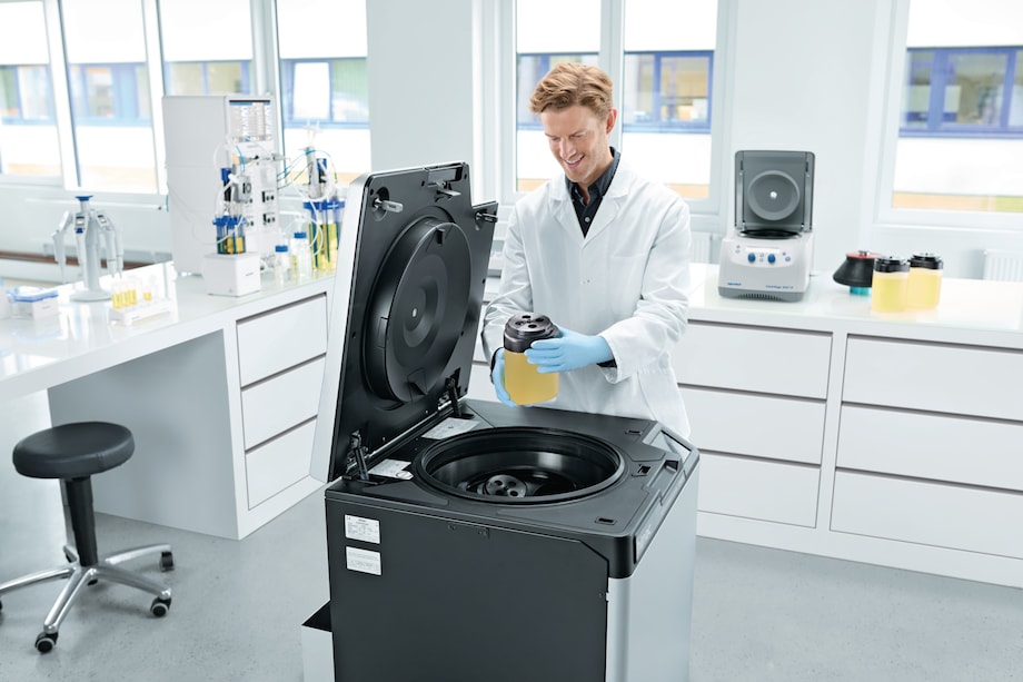 Centrifuge CR22N, key visual, man inserting 1.5 L bottle Man loading 1.5 L bottle into Centrifuge CR22N