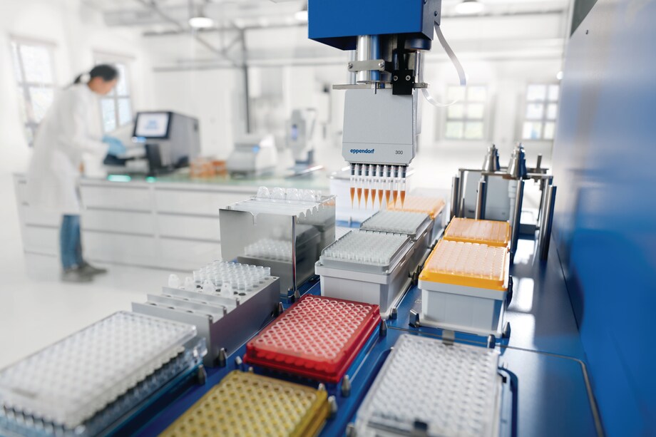 NGS workflow with automated lib prep and lab person View through epMotion workdeck with TM 300 tool with X50 and Illumina sequencer in background with lab person