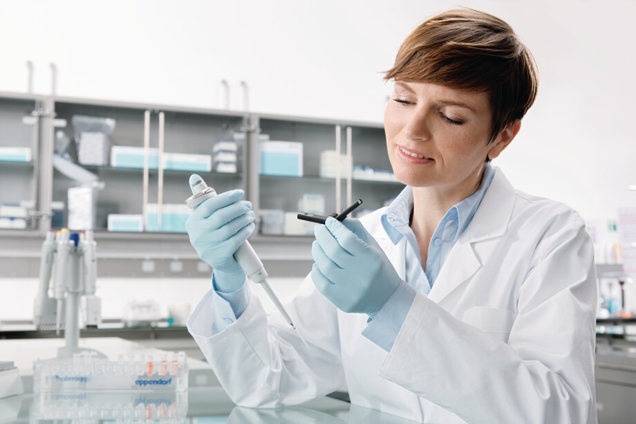 Laboratory technician with Eppendorf Reference_REG_ 2 pipetting into cuvette Laboratory technician with Eppendorf Reference_REG_ 2 pipetting into cuvette