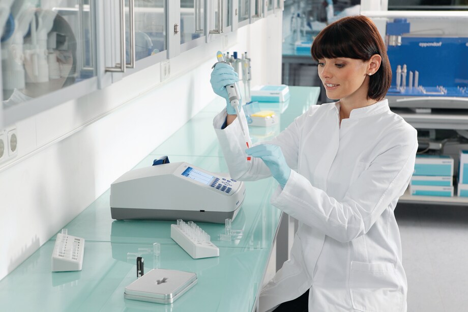 BioPhotometer D30 with scientist Scientist sitting at the bench and filling cuvette for Eppendorf BioPhotometer D30