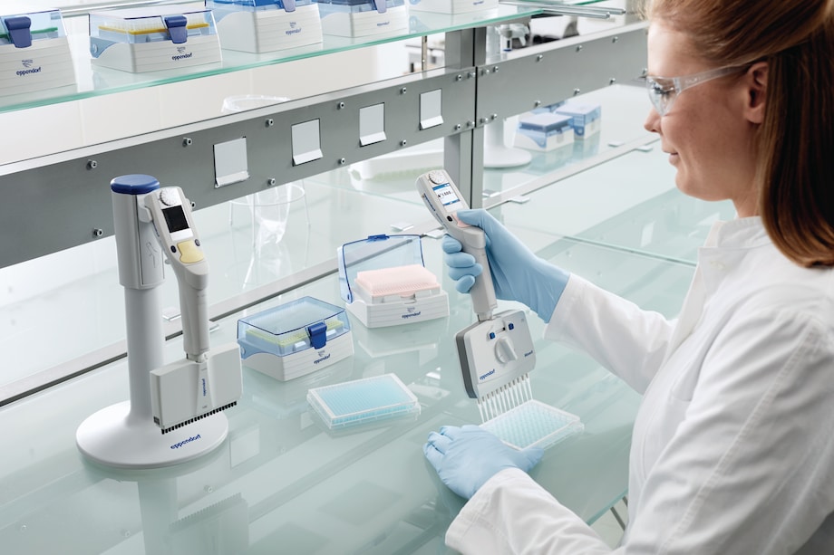 Scientist using a Move It® adjustable tip spacing pipette to dispense liquid into a 384-well plate