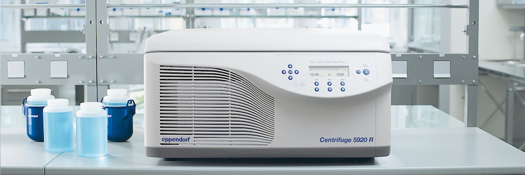 Front view of Eppendorf Centrifuge 5920 R on a laboratory bench and four 1-litre bottles next to it, 2 of which are in buckets