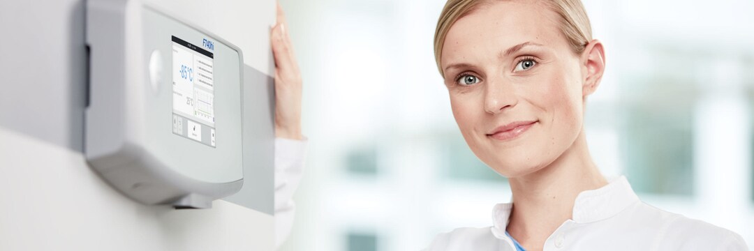 Model facing camera against freezer Lab person leans against ULT freezer